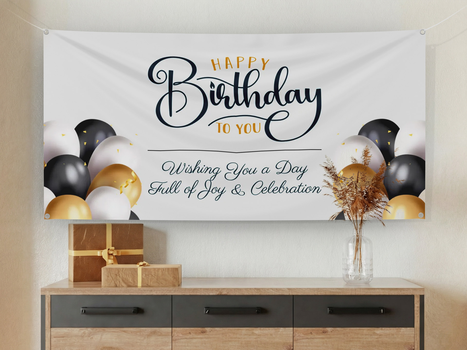 A Happy Birthday themed fabric banner with gold and black balloon decorations