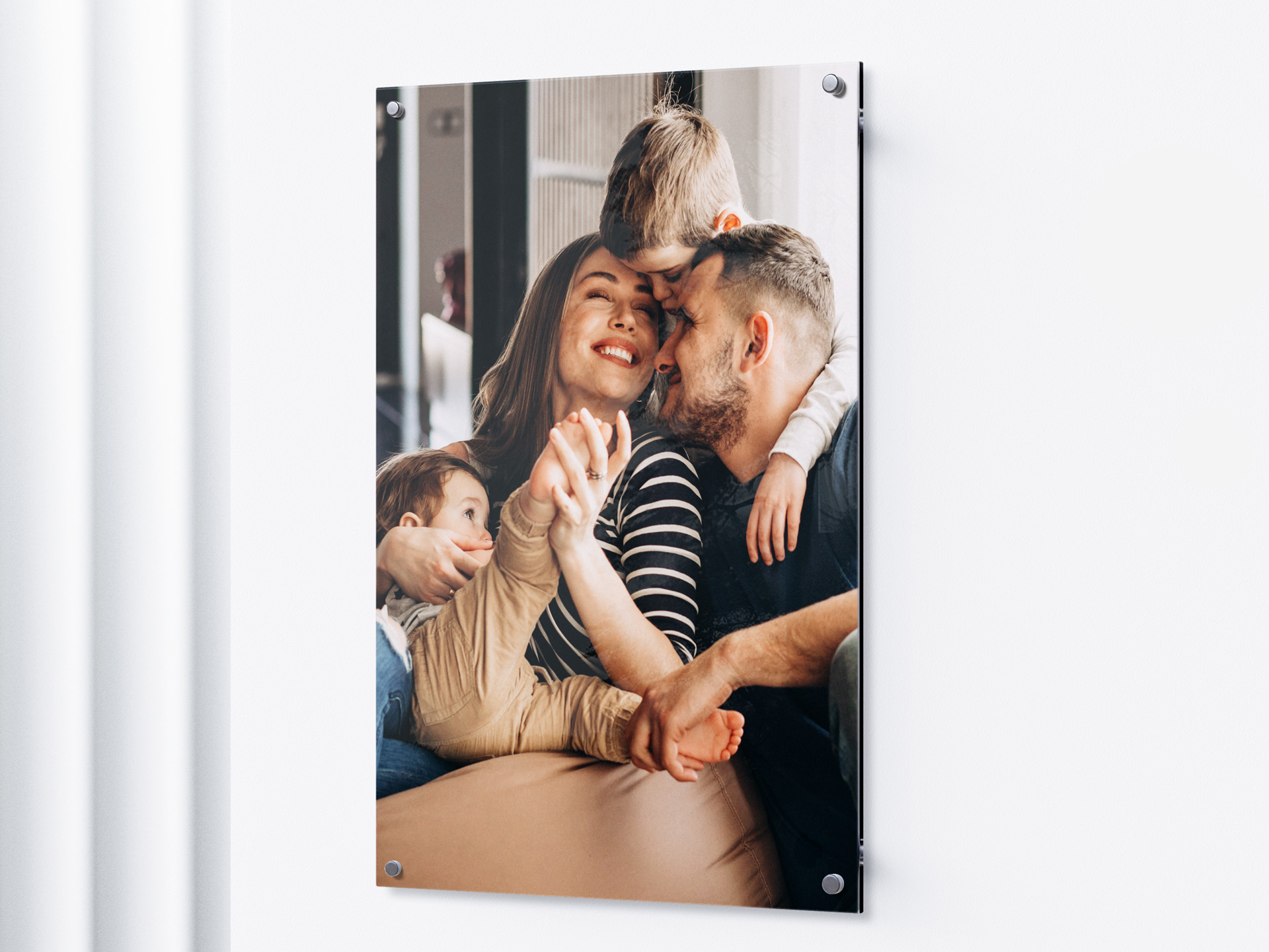 A wall-mounted acrylic photo print featuring a photo of a happy family