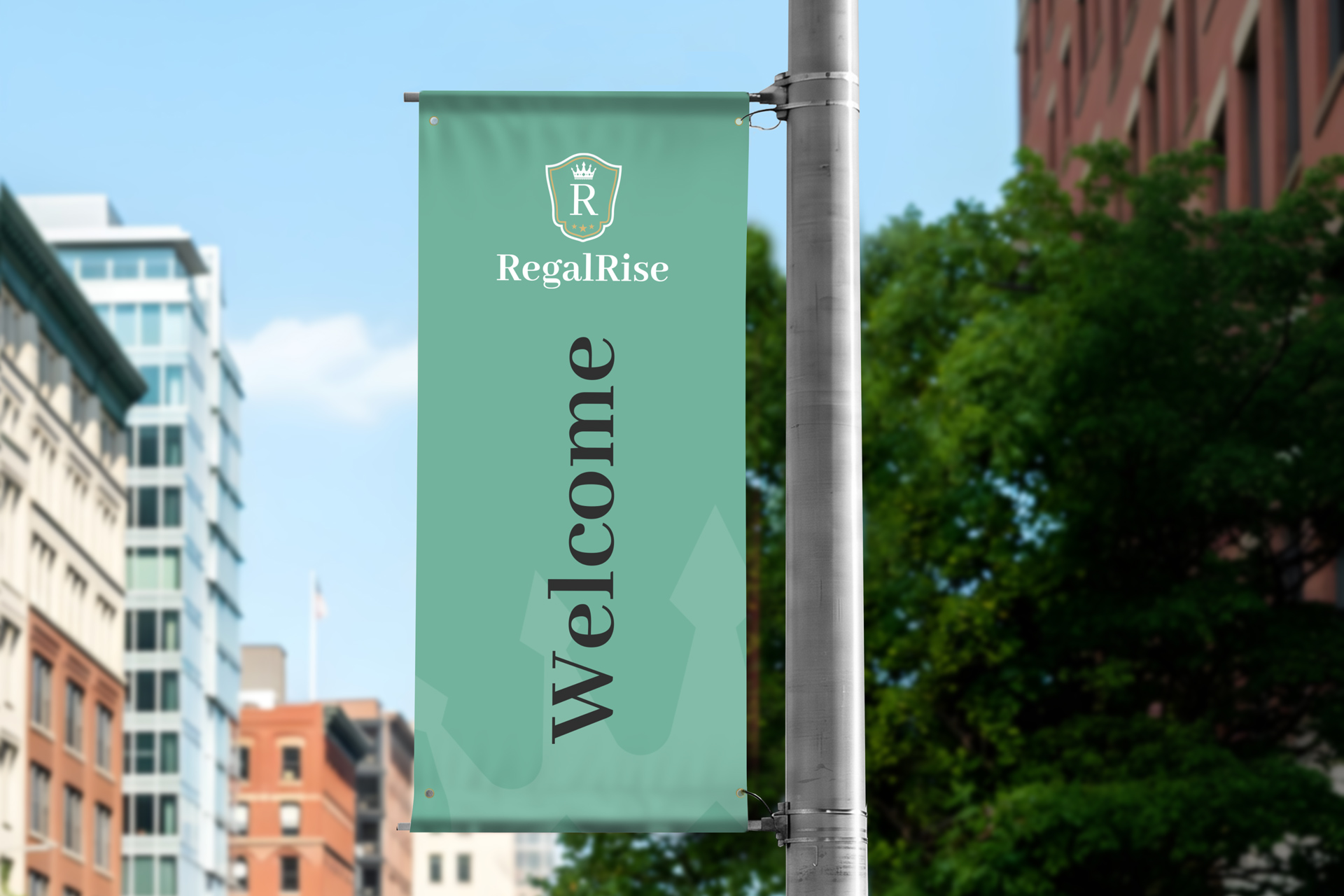 A sage green pole banner mounted on a street pole displaying "Welcome" in white text