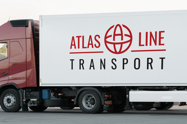 A black and red vehicle lettering decal for a transportation company adhered to a semi truck trailer.