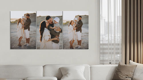 A wall canvas print showing a couple with a child embracing on beach.