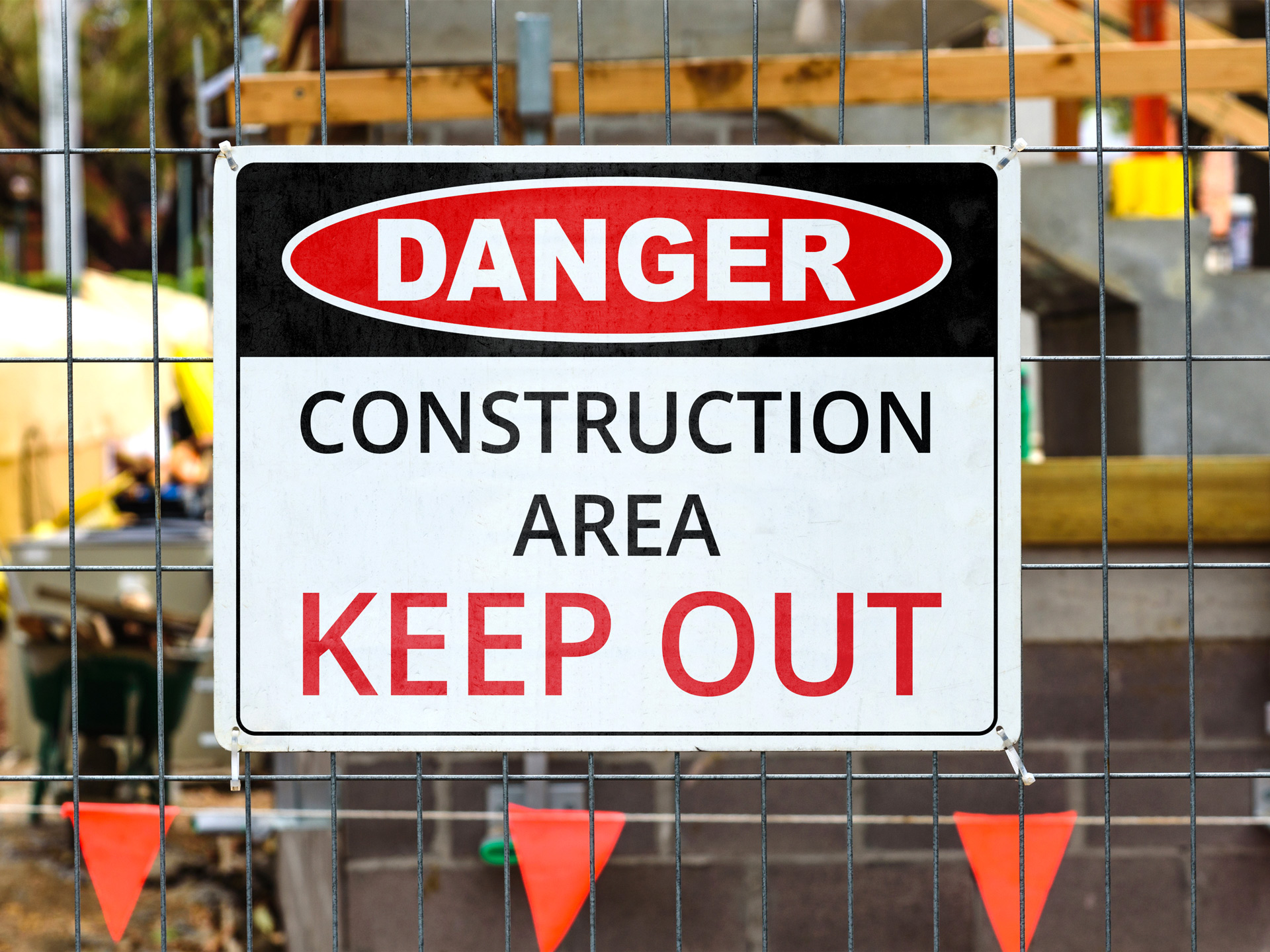 Danger construction area keep out warning sign on metal fence