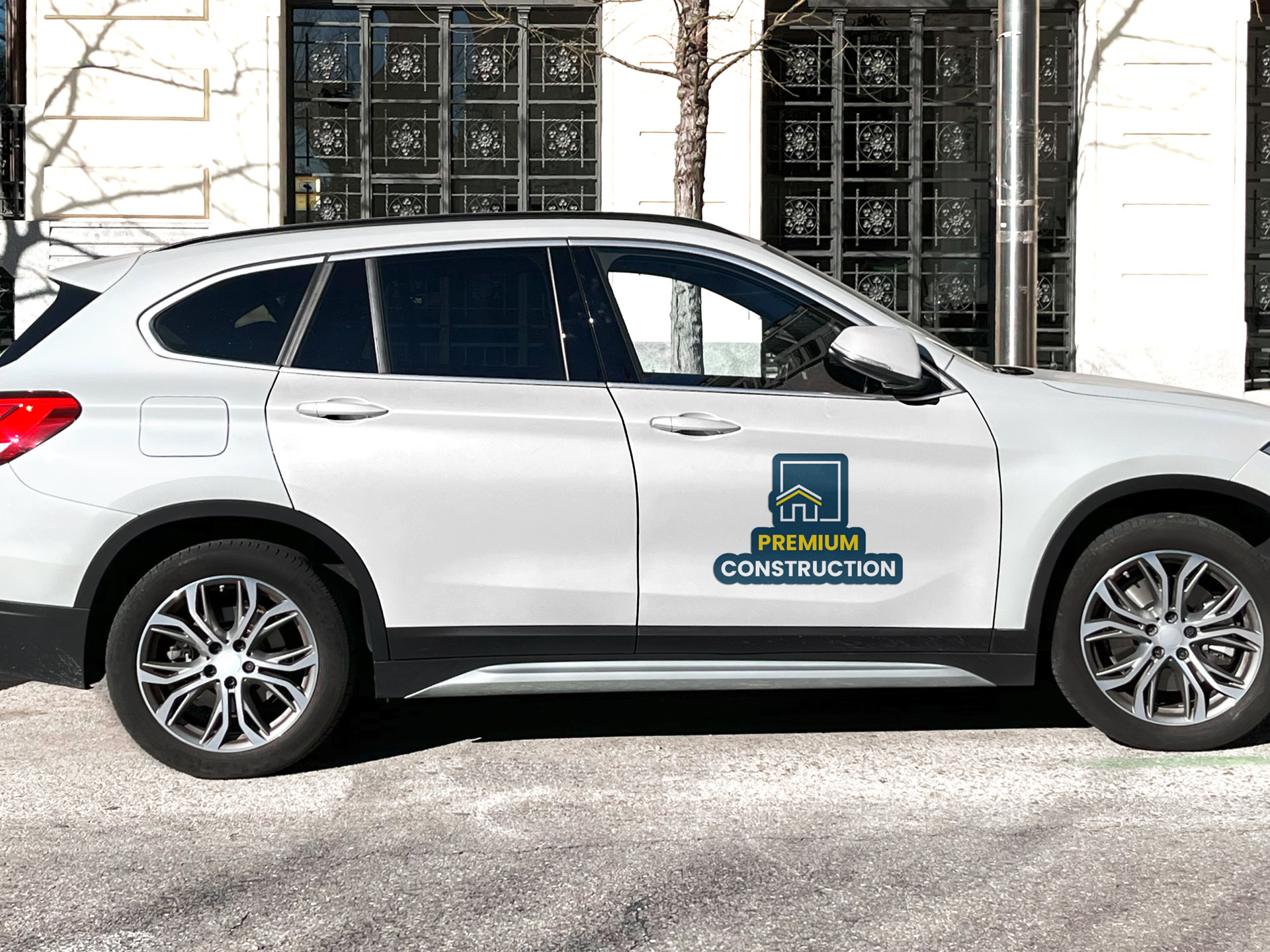 A car magnet for construction company branding attached to the front right door of a company SUV.