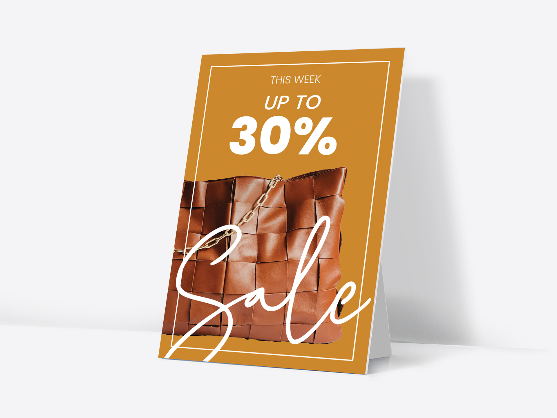 Counter card displaying 30% off sale promotion with brown leather handbag.