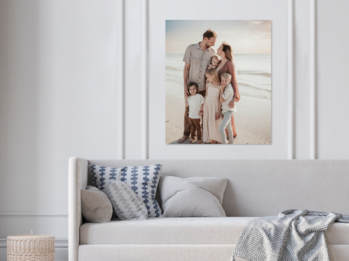 A family portrait on a wrapped canvas print mounted on the wall of a living room.