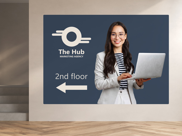 A directional wall decall of a marketing agency with an arrow pointing to a staircase and directing people to the second floor.