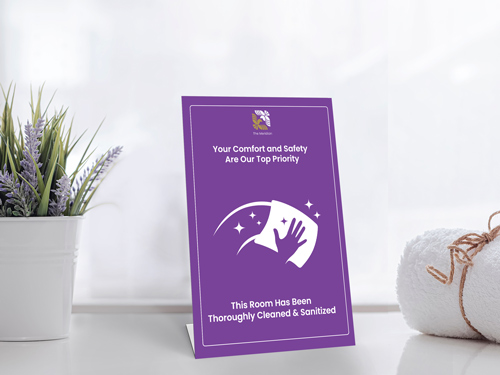 Purple pedestal sign stating the room has been thoroughly cleaned and sanitized for safety.