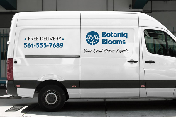 Black and blue vehicle lettering showcasing a flower shop's logo, motto, and phone number adhered to the side of a company van.