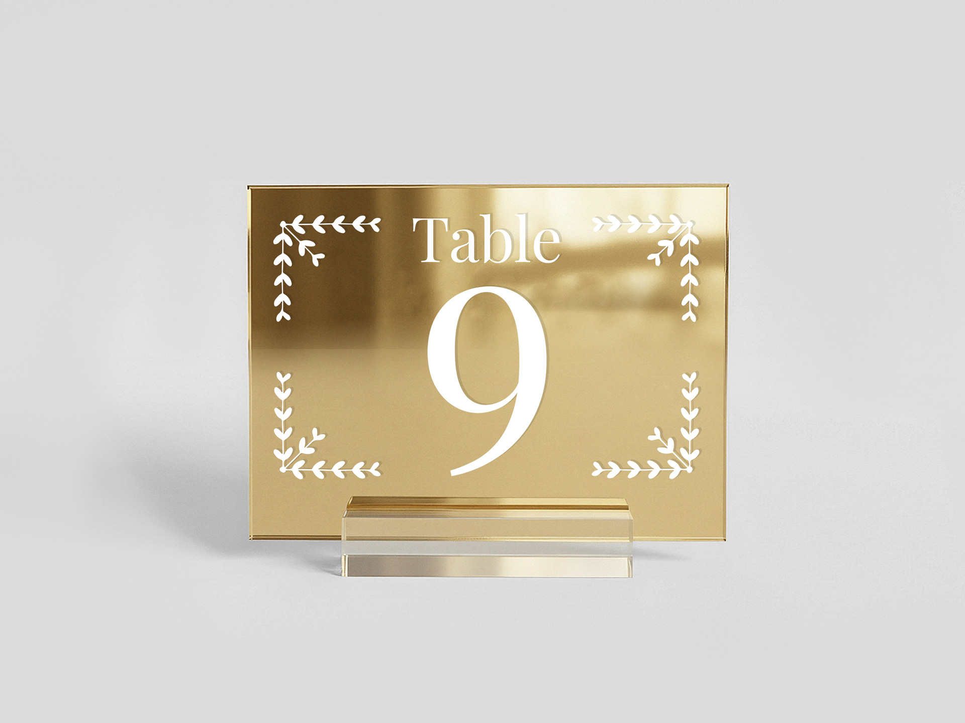 Gold acrylic table sign showing the table number with decorative elements around.