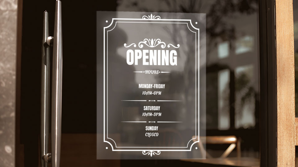 A clear static cling showcasing restaurant business hours adhered to the glass surface
