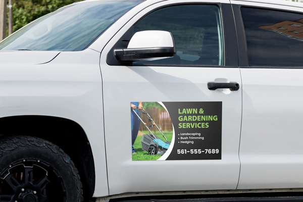 A lawn service company car magnnet showcasing the company name, services, and phone number.