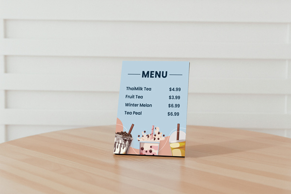 A café menu printed on a PVC board placed in a leaning position on a table.