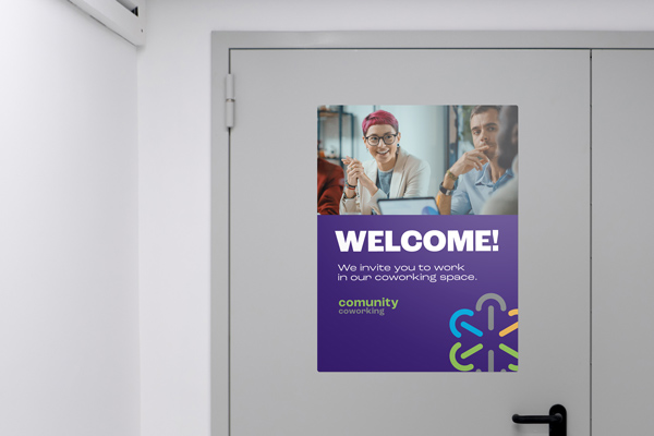 A magnetic event sign attached to a steel door welcoming people to work from a coworking venue.