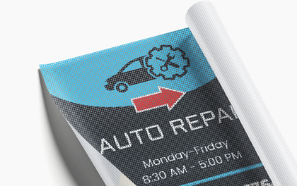 Rolled out mesh banner reading auto repair in blue and black with car and arrow icons