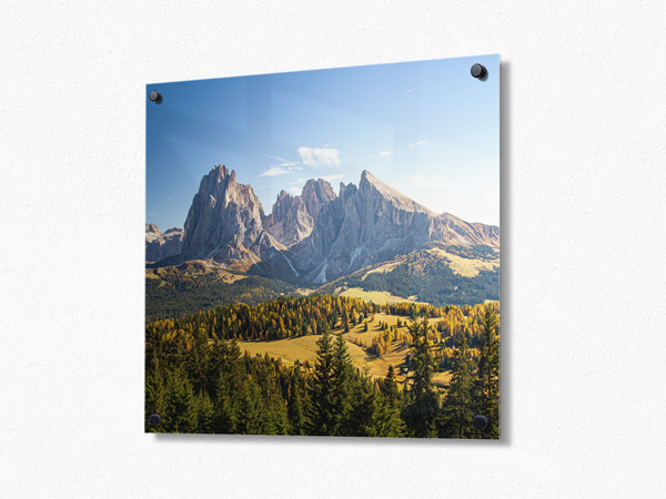 Metal photo prints with alpine peaks rise above green valley.