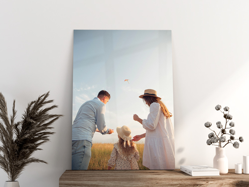 Man and woman in light clothing with a child under soft blue sky.