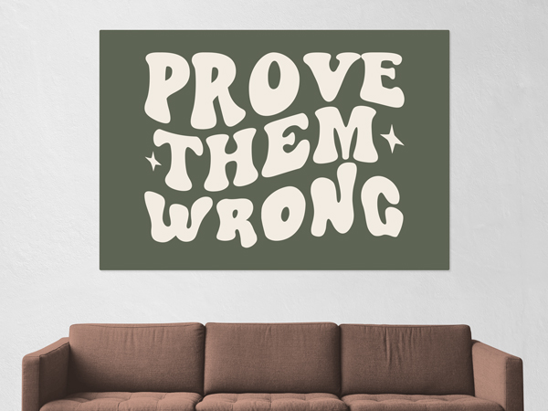 A wall decal with a green background and white text that reads Prove them Wrong adhered to a living room wall.