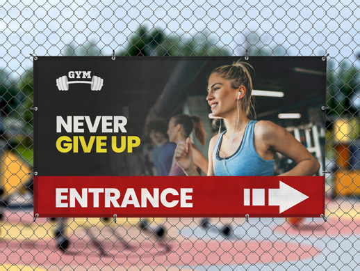 Hanging mesh banner on a fence reading construction services