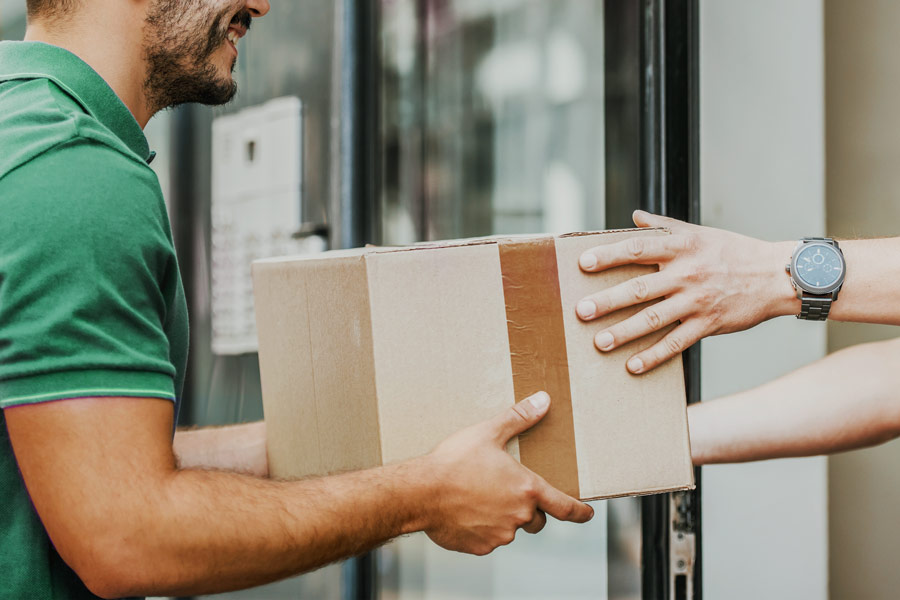 An image of a delivery person handing over a package to a recipient.