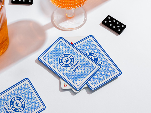 Classic playing cards with a blue geometric back design and company branding, partially revealing a red-suited card underneath