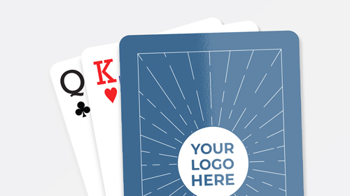 Customized playing cards with a blue back design featuring a placeholder for a logo, partially revealing a Queen of Clubs and King of Hearts