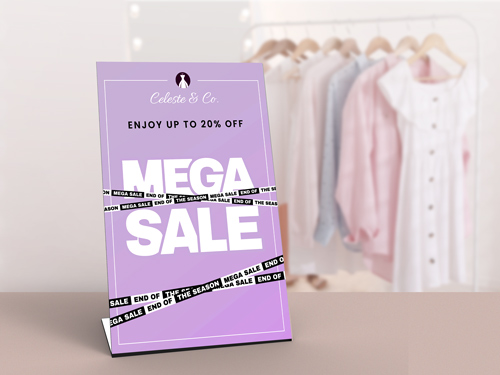 Pedestal sign with "Mega Sale" text in a clothing store, offering up to 20% off.