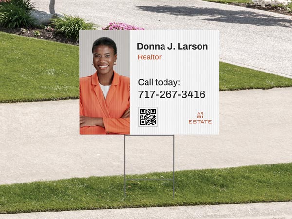 A custom yard sign promoting a realtor's services and her contact information.