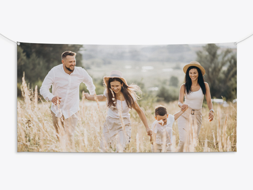 A rolled canvas print depicting a happy family in a field hung on the home wall.