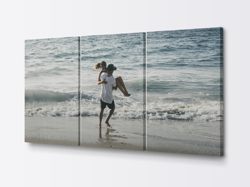 A beautiful split canvas print in three panels showcasing a happy couple on the shore.
