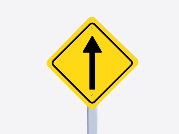A yellow reflective aluminum sign with a black border and a black arrow pointing forward in its center.