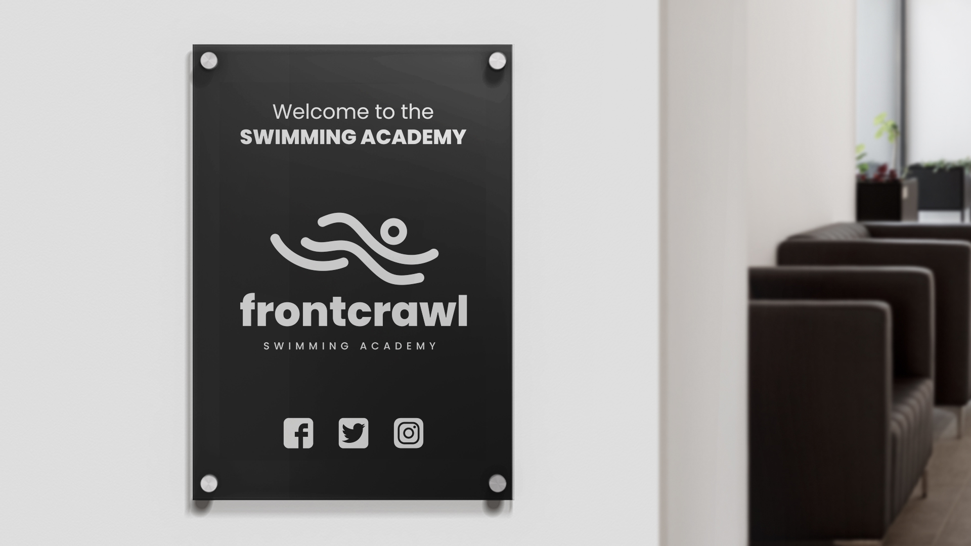 Black acrylic lobby sign welcoming visitors to swimming academy
