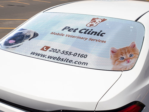 Advertising window decal with a perforated finish applied on a car for a pet clinic