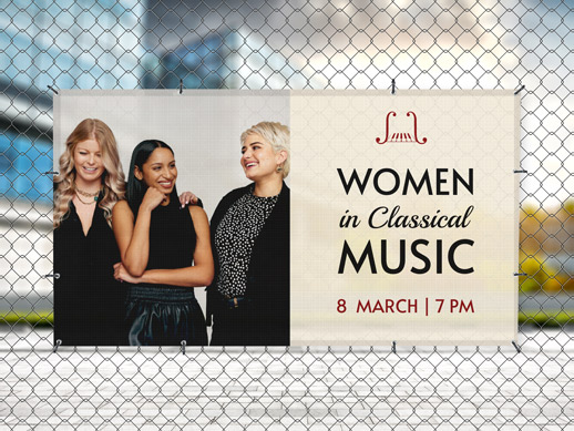 Hanging mesh banner on a fence reading construction services