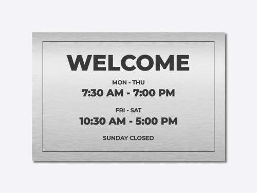 Welcoming brushed aluminum sign reading the business working hours.