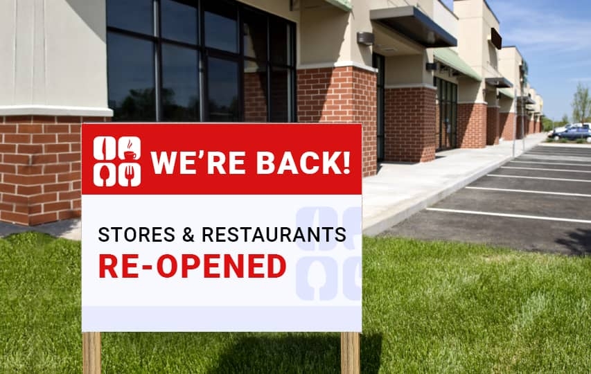 Informative wooden signs for a restaurant in red and white reading We're Back.