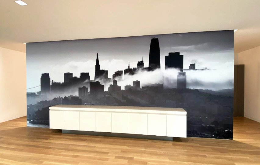 Black-and-white city skyline wall art decal with fog effect behind a modern white cabinet.
